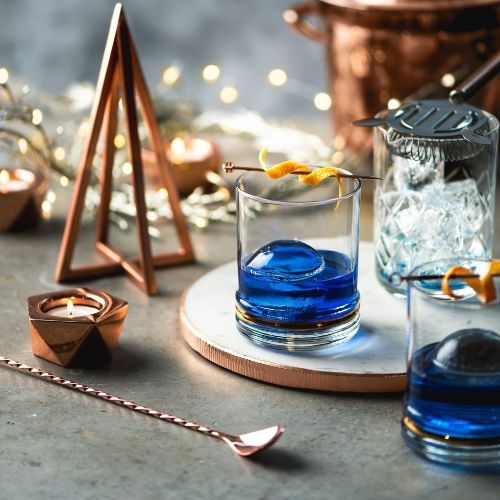 Empress Old Fashioned cocktail made with Kitapo African Gin, garnished with orange peel and herbs in a lowball glass